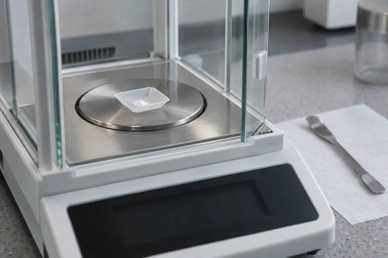 Analytical balance with a weighing spatula